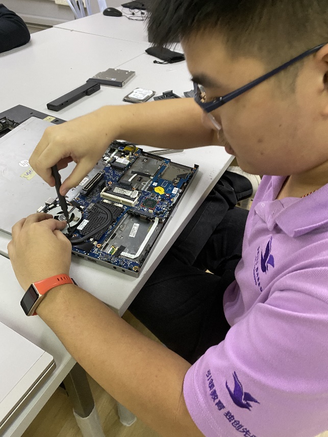 SBIT student hands on fixing laptop