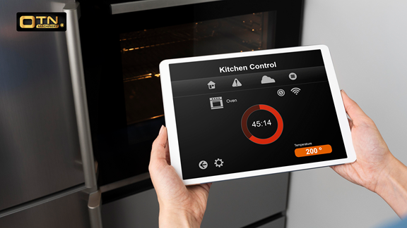 A person holds a tablet displaying an app for oven control