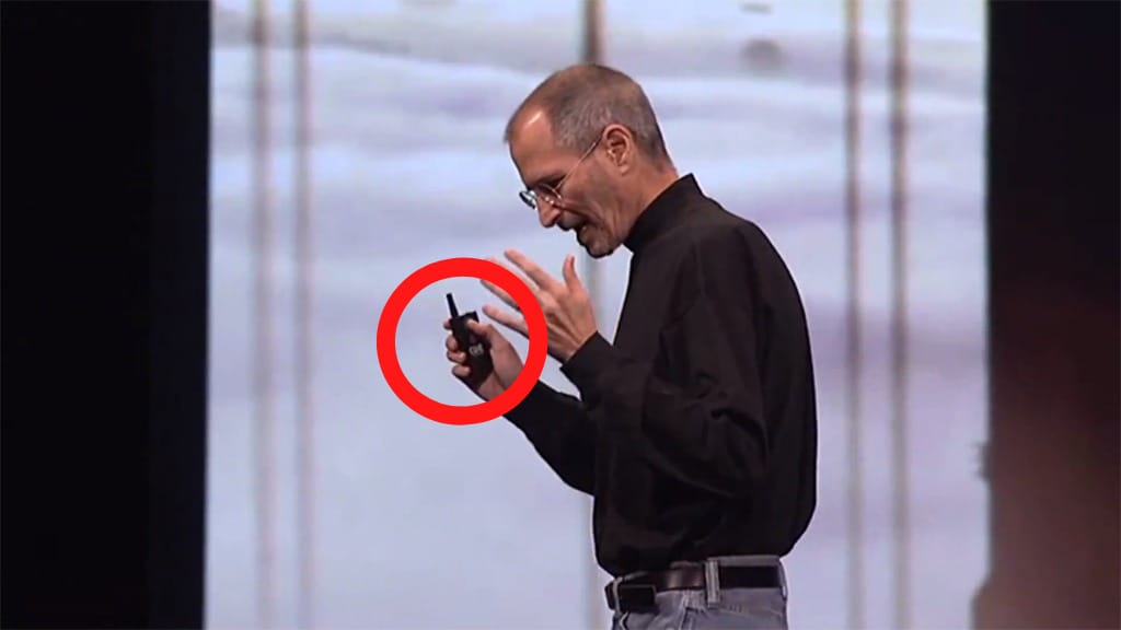 Presenter holding wireless presentation clicker during live speech