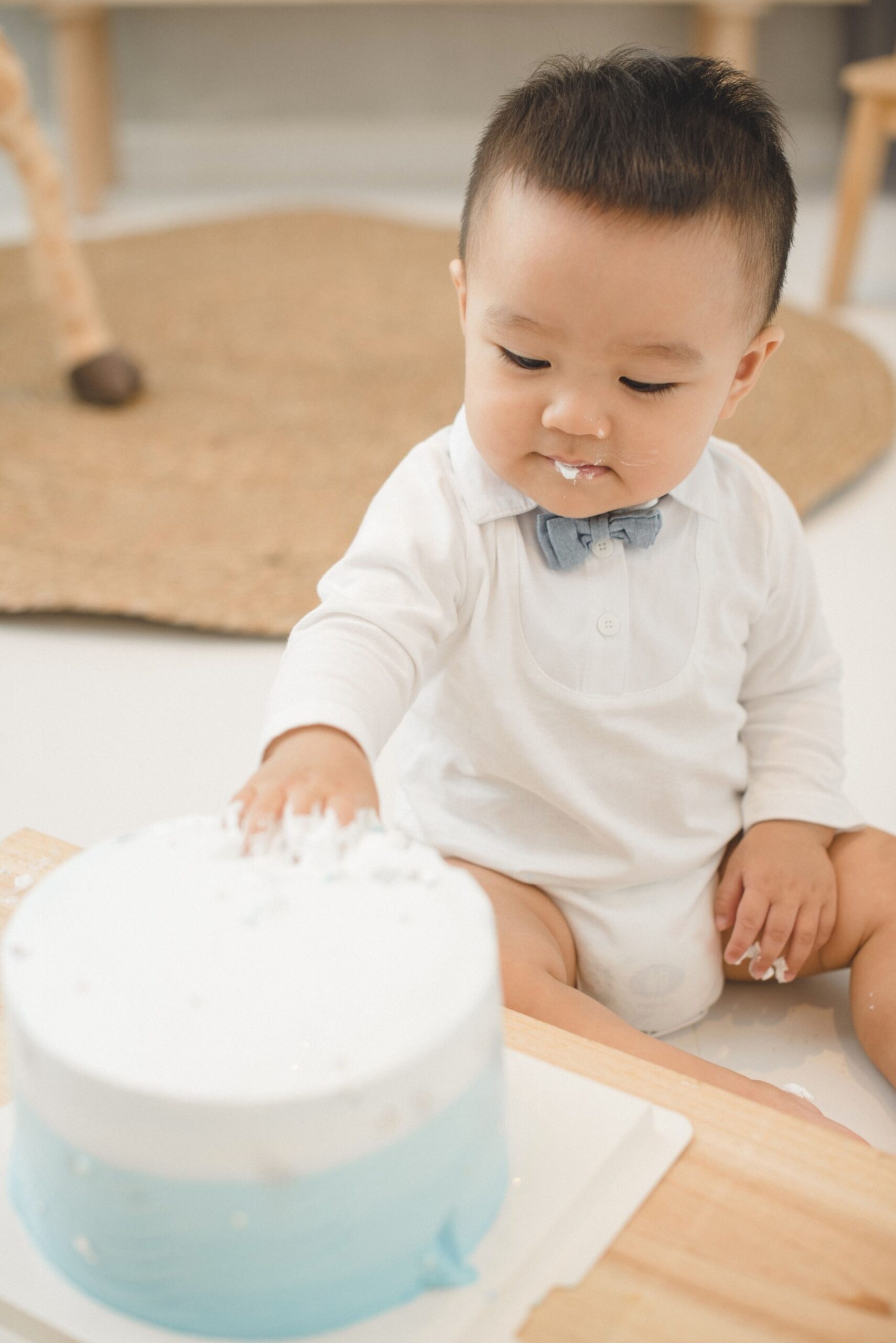 Close-up cake smash photography showing baby exploring birthday cake frosting