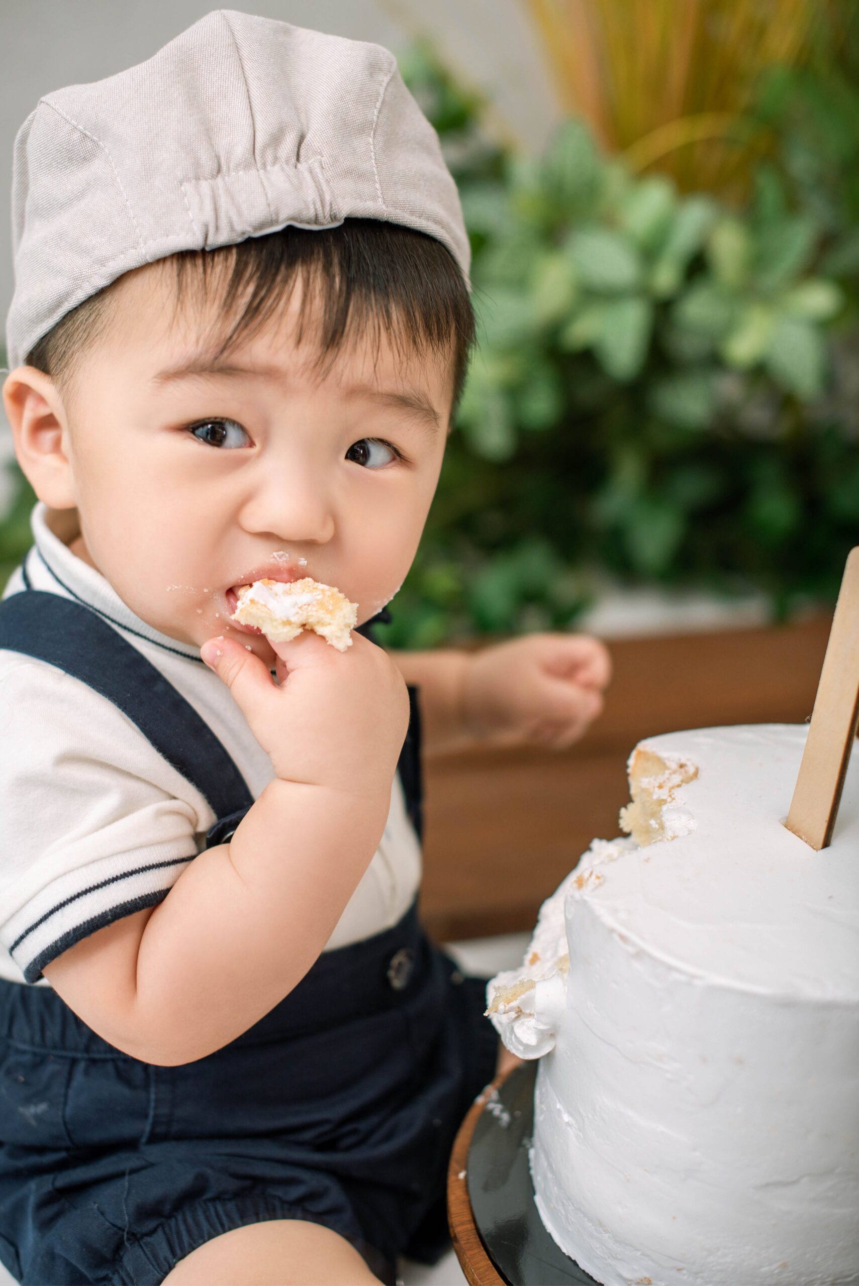Minimal cake smash portrait featuring baby with birthday cake and milestone hat