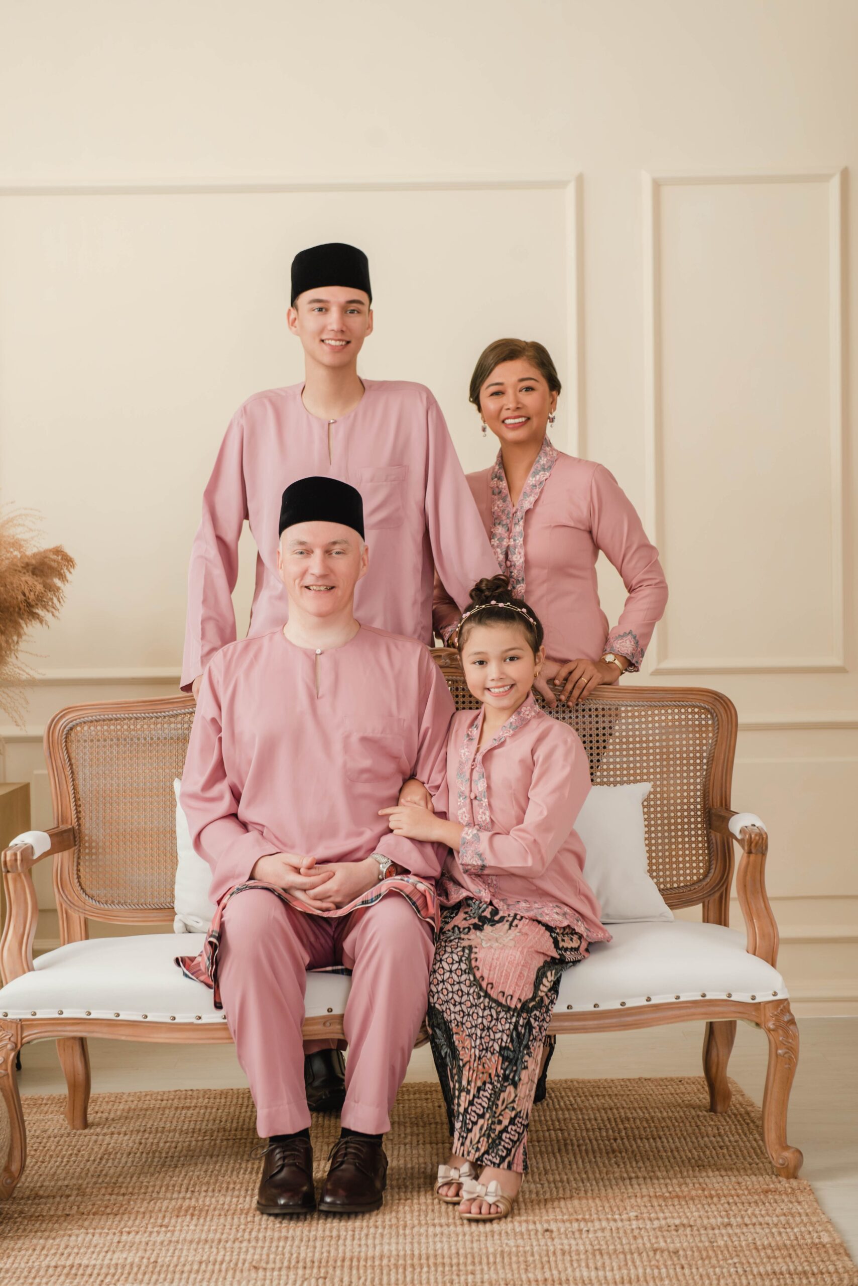 Elegant multi-generation family portrait in a soft neutral studio setting