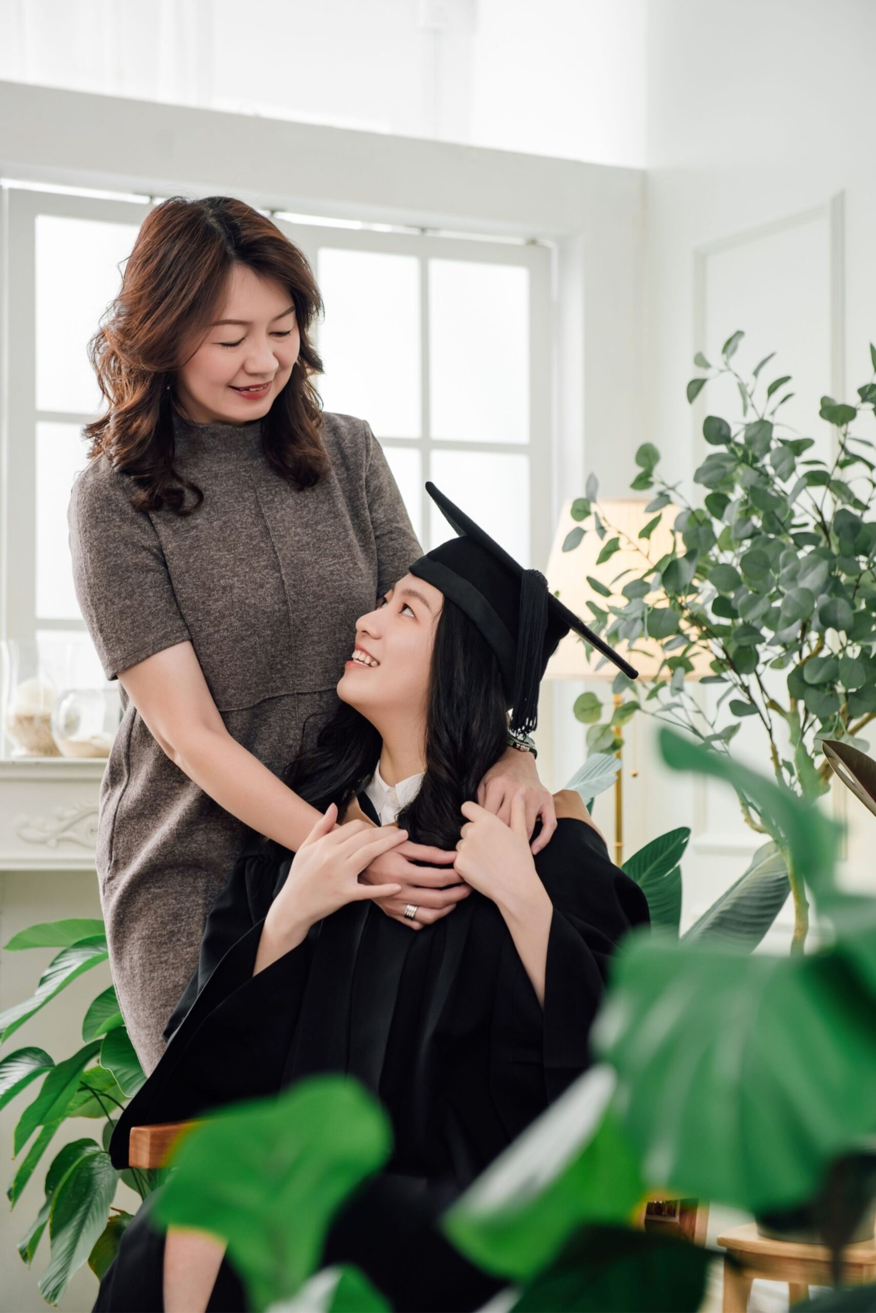 Graduation family photography with mother and graduate sharing a warm proud moment