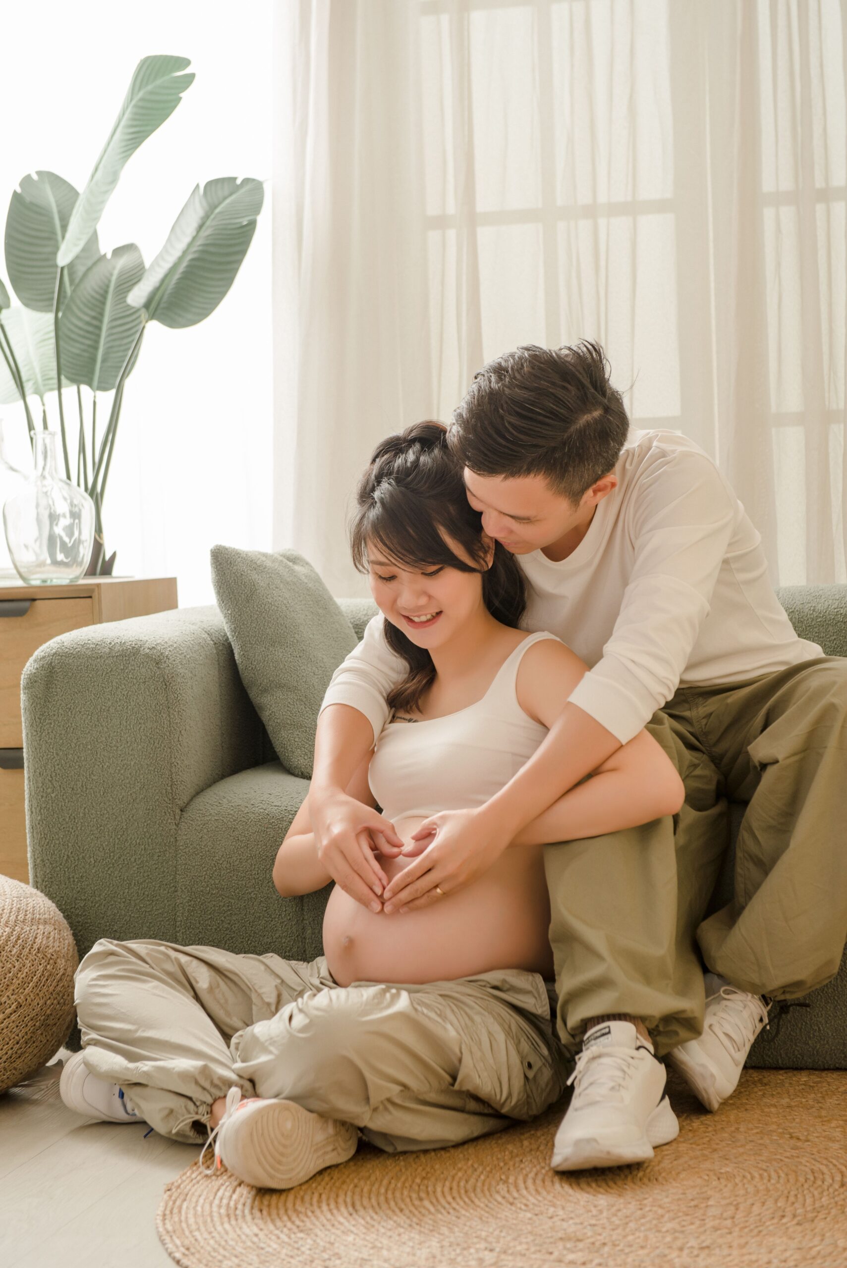 Lifestyle maternity portrait of expecting couple embracing at home